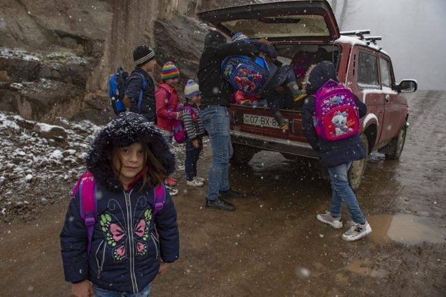A driver goes around the village and picks up pupils from their homes. He takes the children most of the way, but they need to complete the journey alone on foot. Photo: Orkhan Azimov
